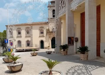 Portico con colonne e campanile del santuario dei Carmelitani scalzi a Ragusa, con luminarie e palco nella piazza