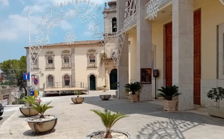 Portico con colonne e campanile del santuario dei Carmelitani scalzi a Ragusa, con luminarie e palco nella piazza