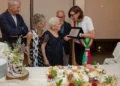 Centenaria di Modica Maria Cavallo riceve una targa dalla sindaca con fascia tricolore, davanti una torta a forma di 100