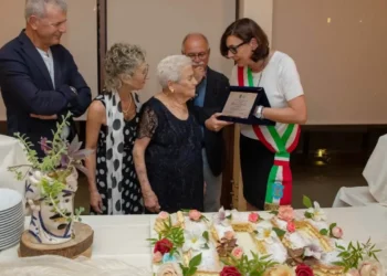 Centenaria di Modica Maria Cavallo riceve una targa dalla sindaca con fascia tricolore, davanti una torta a forma di 100