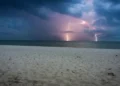 Temporale con fulmini sul mare, visto da una spiaggia al crepuscolo