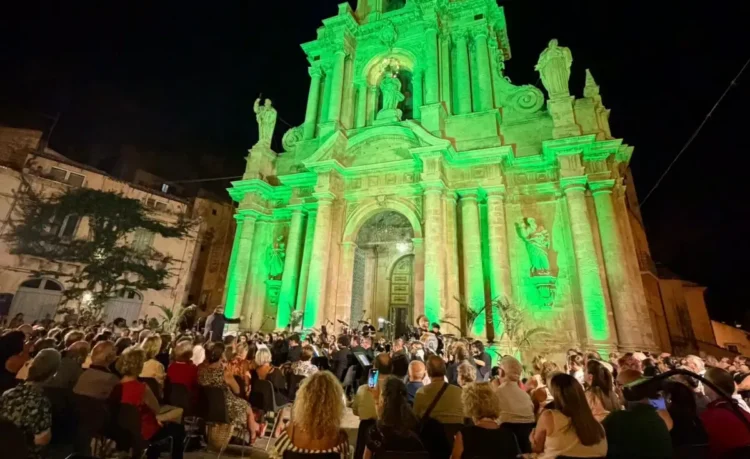 Il pubblico assiste al concerto della banda Busacca-Borrometi davanti alla facciata illuminata di San Bartolomeo a Scicli