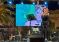Manuela Villa canta sul palco durante il concerto ad Ispica, schermo led alle spalle e tastierista sul lato sinistro