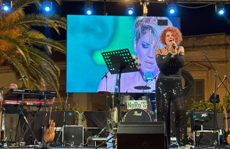 Manuela Villa canta sul palco durante il concerto ad Ispica, schermo led alle spalle e tastierista sul lato sinistro