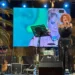Manuela Villa canta sul palco durante il concerto ad Ispica, schermo led alle spalle e tastierista sul lato sinistro