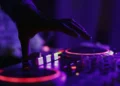 Mano di un dj su una consolle luminosa durante un dj set in un locale notturno
