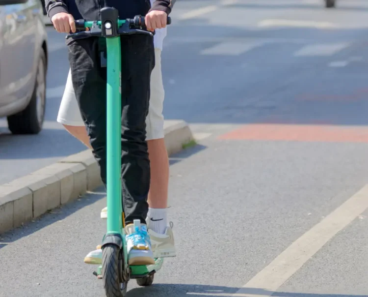 Monopattino elettrico con due persone a bordo lungo una strada urbana di Vittoria