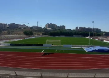 Vista dall'alto del campo e della pista d'atletica dello stadio Pietro Scollo di Modica, tribune vuote sullo sfondo