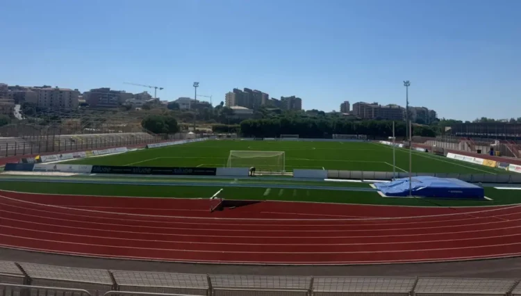 Vista dall'alto del campo e della pista d'atletica dello stadio Pietro Scollo di Modica, tribune vuote sullo sfondo