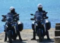 Agenti della Polizia di Stato pattugliano in moto una banchina vicino al mare