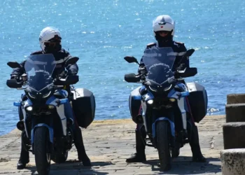 Agenti della Polizia di Stato pattugliano in moto una banchina vicino al mare