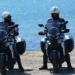 Agenti della Polizia di Stato pattugliano in moto una banchina vicino al mare