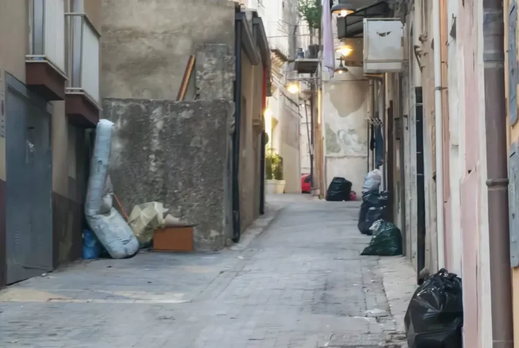 Vicolo del centro storico di Ragusa con rifiuti e ingombranti abbandonati sul marciapiede