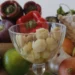 Peperoni colorati, cipolle, lime e una coppa di vetro con spicchi d'aglio sbucciati: ingredienti da dieta mediterranea