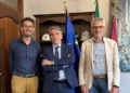 Tre persone in un ufficio istituzionale con bandiere alle spalle, per la campagna Disconnetti la truffa a Ragusa