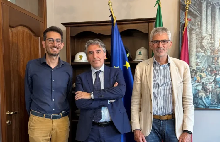 Tre persone in un ufficio istituzionale con bandiere alle spalle, per la campagna Disconnetti la truffa a Ragusa