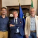 Tre persone in un ufficio istituzionale con bandiere alle spalle, per la campagna Disconnetti la truffa a Ragusa