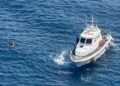Motovedetta della Guardia Costiera accanto a un giovane in mare a Catania