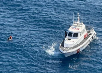 Motovedetta della Guardia Costiera accanto a un giovane in mare a Catania