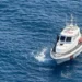 Motovedetta della Guardia Costiera accanto a un giovane in mare a Catania