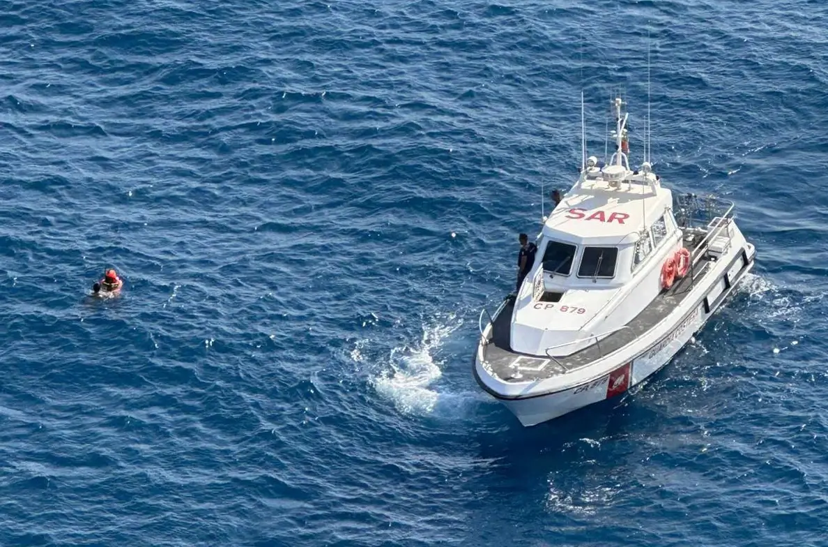 Motovedetta della Guardia Costiera accanto a un giovane in mare a Catania