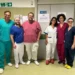 Équipe dell'ambulatorio FNAV per l'elettromiografia del collo all'ospedale di Comiso, in posa davanti alla porta del servizio