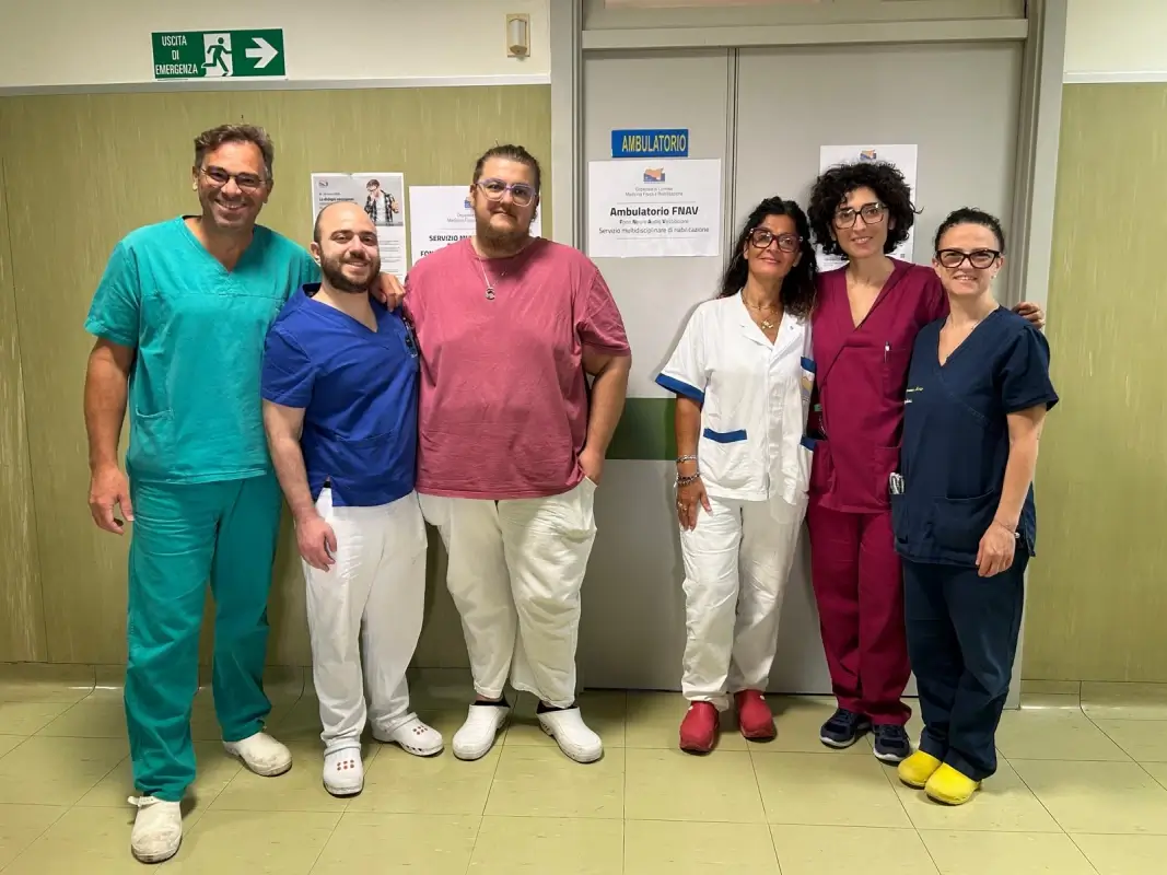 Équipe dell'ambulatorio FNAV per l'elettromiografia del collo all'ospedale di Comiso, in posa davanti alla porta del servizio