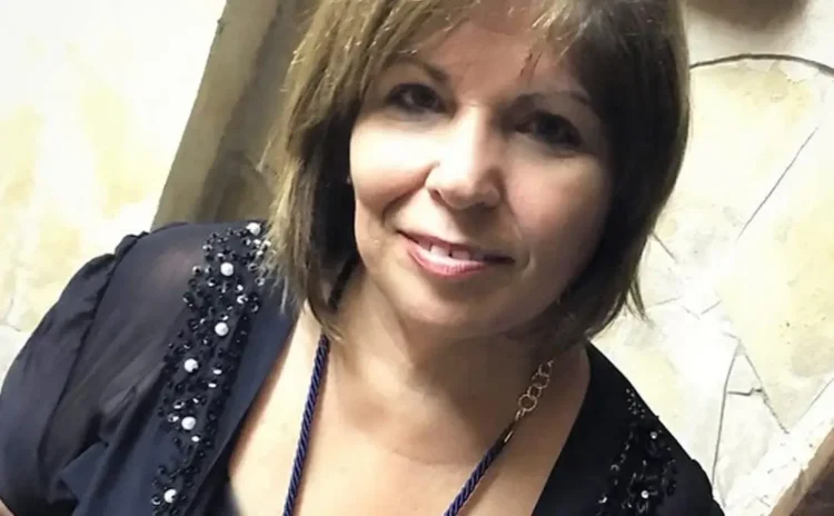 Enza Forti, maestra di Comiso, sorride all'obiettivo: capelli castani a caschetto, blusa scura ricamata e collana blu.