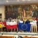 Giovani dello scambio Erasmus a Modica con le bandiere di Italia, Sicilia, Polonia e Unione Europea in una sala del Comune