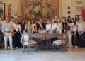 Il sindaco di Scicli con la fascia tricolore posa in Municipio con studenti e docenti, accanto a una scrivania d'epoca