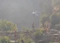Elicottero dei vigili del fuoco sorvola i Laghetti di Cavagrande durante il soccorso, bagnanti sulle terrazze rocciose