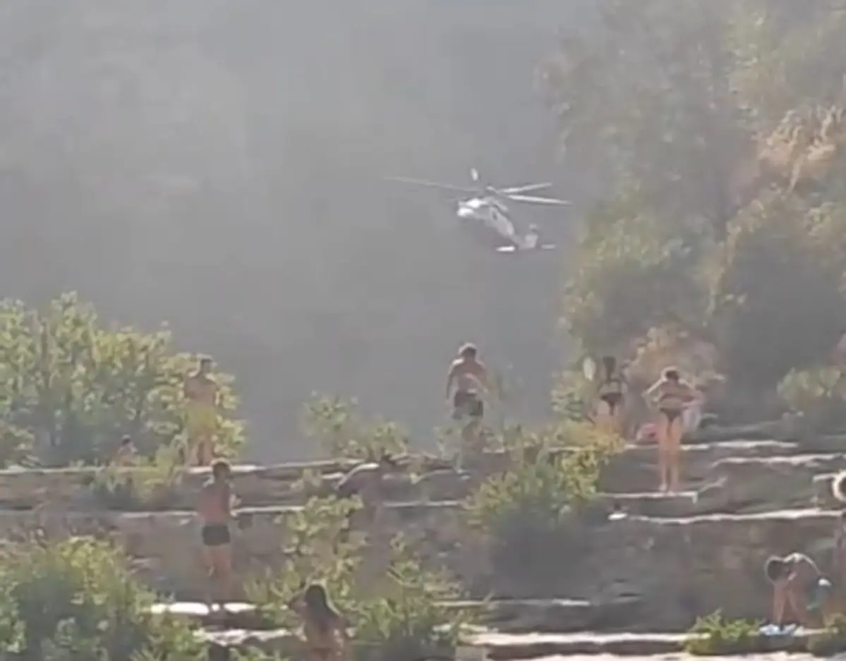 Elicottero dei vigili del fuoco sorvola i Laghetti di Cavagrande durante il soccorso, bagnanti sulle terrazze rocciose