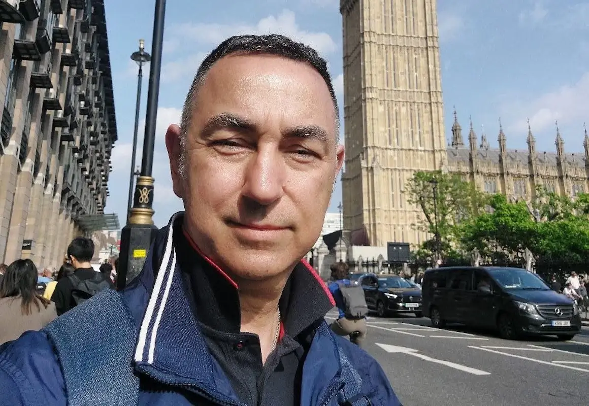 Fabio Saraceno in un selfie a Londra davanti alla torre del Big Ben, con giacca blu, in una giornata di sole