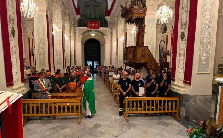 Interno della chiesa a Monterosso Almo durante la messa con vigili del fuoco, forestali e il sindaco con fascia tricolore