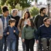 Persone di ogni età, tra cui un uomo in sedia a rotelle, in una piazza. Immagine generata con intelligenza artificiale
