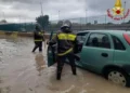 Vigili del fuoco soccorrono un automobilista durante un forte temporale a Palermo