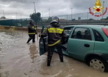 Vigili del fuoco soccorrono un automobilista durante un forte temporale a Palermo