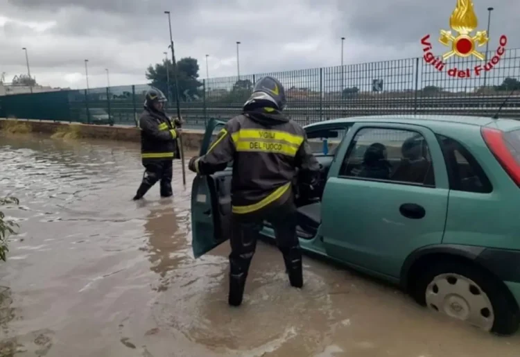 Vigili del fuoco soccorrono un automobilista durante un forte temporale a Palermo