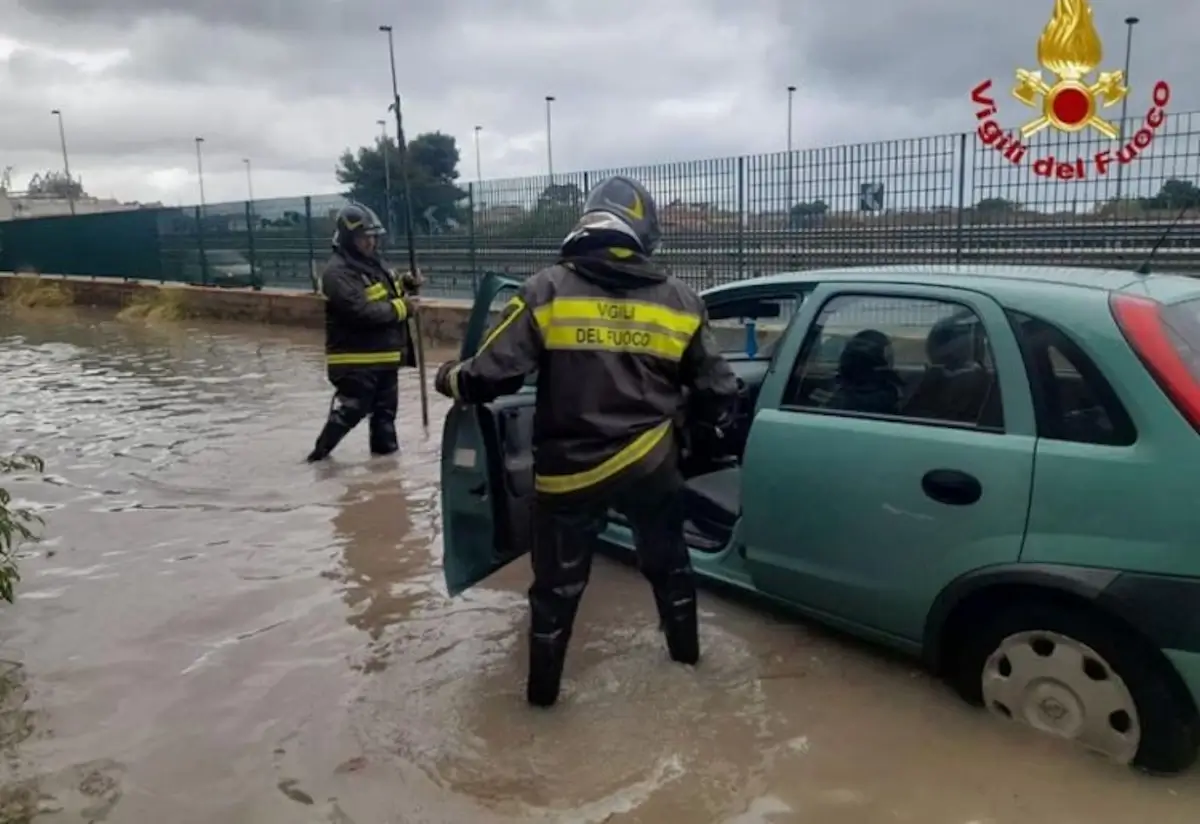 Vigili del fuoco soccorrono un automobilista durante un forte temporale a Palermo