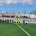 Giocatori di Frigintini e Pro Ragusa schierati a centrocampo con la terna arbitrale prima del derby di Promozione