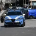 Auto della Polizia di Stato in transito su una via cittadina tra traffico e pedoni