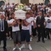 Giovani in maglietta bianca portano il feretro durante i funerali a Pozzallo