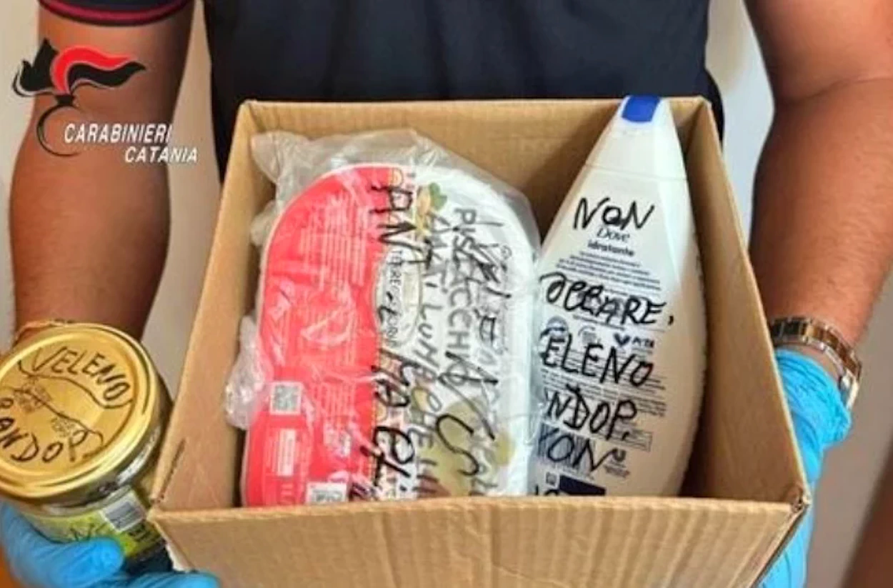 Un carabiniere con guanti blu mostra una scatola con i veleni sequestrati a Ramacca: un barattolo e dei flaconi con la scritta «veleno»