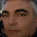 Gianni Celeste in un primo piano all'aperto, capelli brizzolati e sopracciglia folte, giacca scura