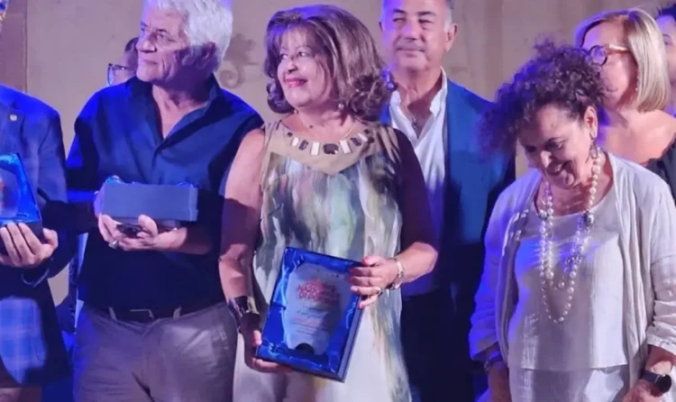 Giovanna Drago sul palco a Partanna con la targa del Premio Nazionale di Poesia, tra altri premiati