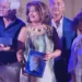 Giovanna Drago sul palco a Partanna con la targa del Premio Nazionale di Poesia, tra altri premiati
