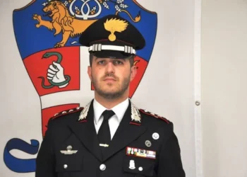 Il Maggiore Giovanni Ronchi in uniforme dei Carabinieri davanti allo stemma dell’Arma.