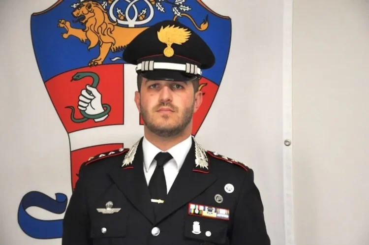 Il Maggiore Giovanni Ronchi in uniforme dei Carabinieri davanti allo stemma dell’Arma.