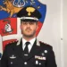 Il Maggiore Giovanni Ronchi in uniforme dei Carabinieri davanti allo stemma dell’Arma.
