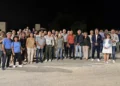 Decine di persone in posa di notte su una strada di campagna per l'accensione dell'illuminazione sulla Spinazza a Donnalucata